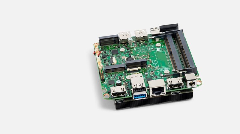 Bare green NUC circuit board with chip, ports, and heatsink