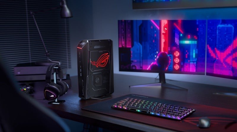 Compact black gaming NUC tower on a desk beside a monitor
