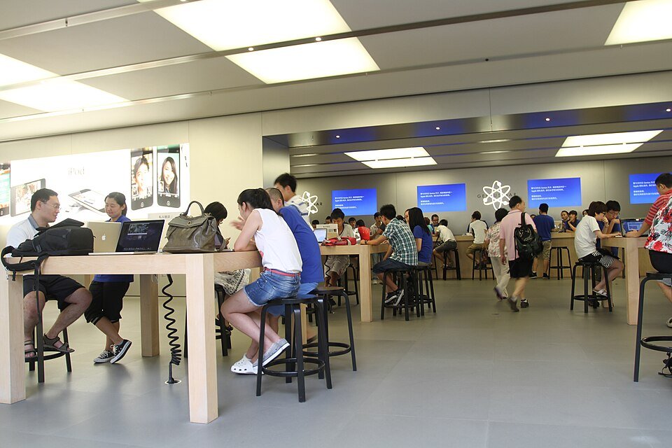Customers seated at an Apple Store Genius Bar table