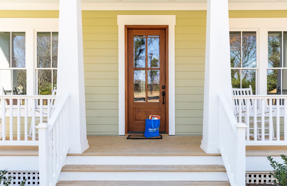 Blue Walmart delivery bag waiting at a front door on a porch