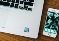 Outlook app sync settings - laptop and phone on an office desk