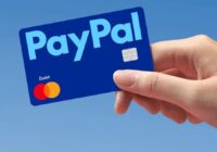 Hand holding a blue PayPal Debit Mastercard
