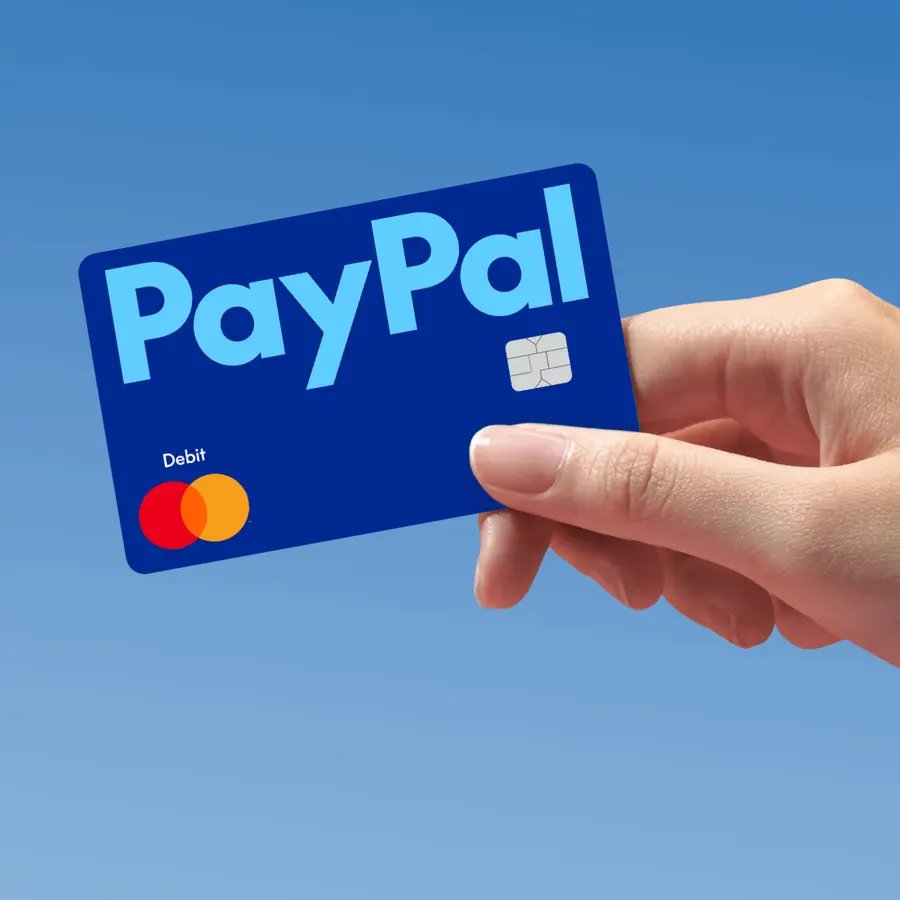 Hand holding a blue PayPal Debit Mastercard