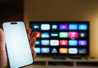 Cast phone to TV - smartphone in front of a smart TV