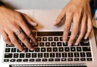 Remove an email account from Outlook - hands typing on a laptop