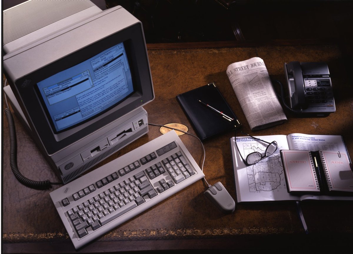 IBM PS/2 desktop on an office desk with its monitor showing a program window