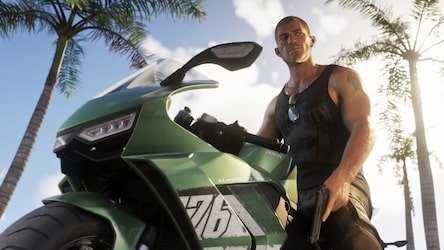 Man in black tank top beside a green motorcycle under palm trees