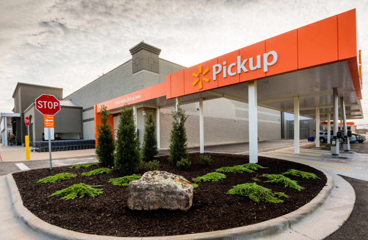 Orange Walmart Pickup canopy over reserved parking spaces outside a Supercenter