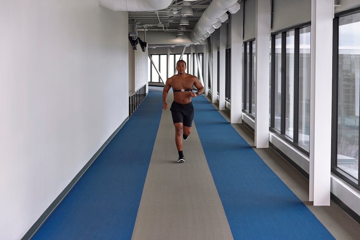 Runner on an indoor track wearing a Garmin HRM-Pro Plus chest strap