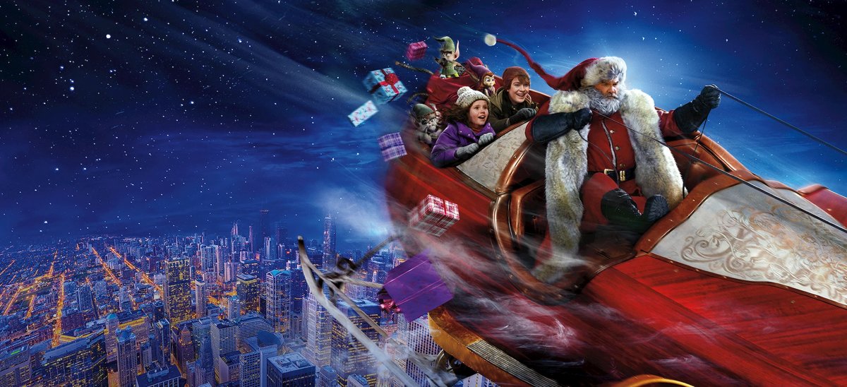Santa's sleigh flying over a night city with two children and elves aboard