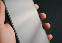 iPhone 11 won't turn on - hand holding a phone on a dark background