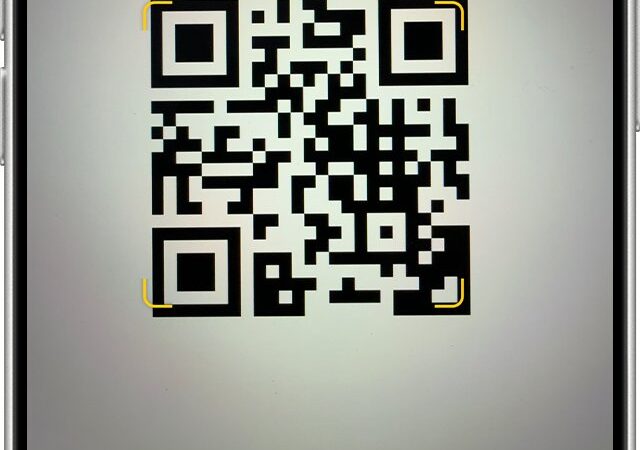 iPhone Camera app framing a QR code with a yellow link banner below it